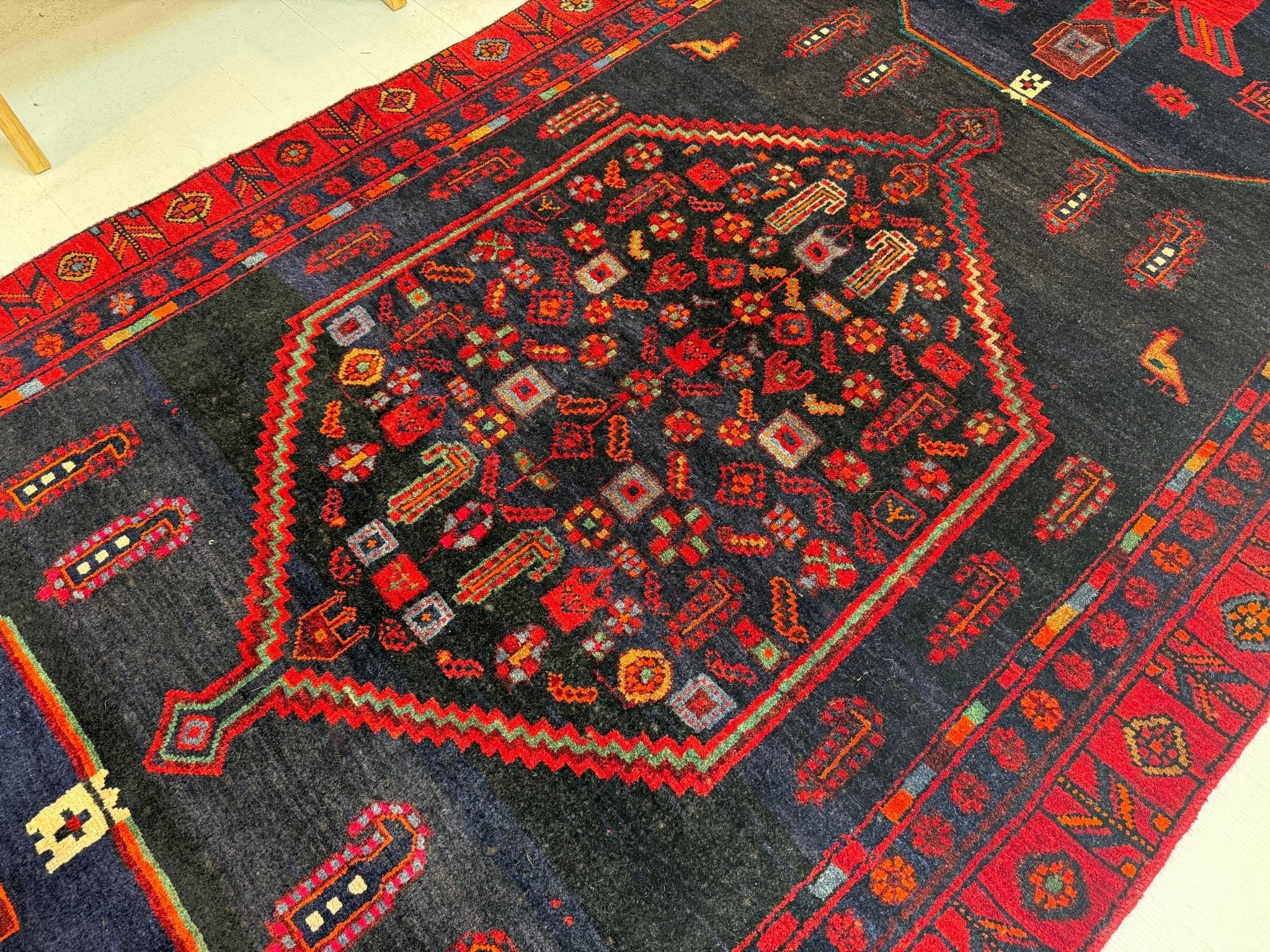 Kurdish Koliai rug with dark gray center medallion and red border geometric designs