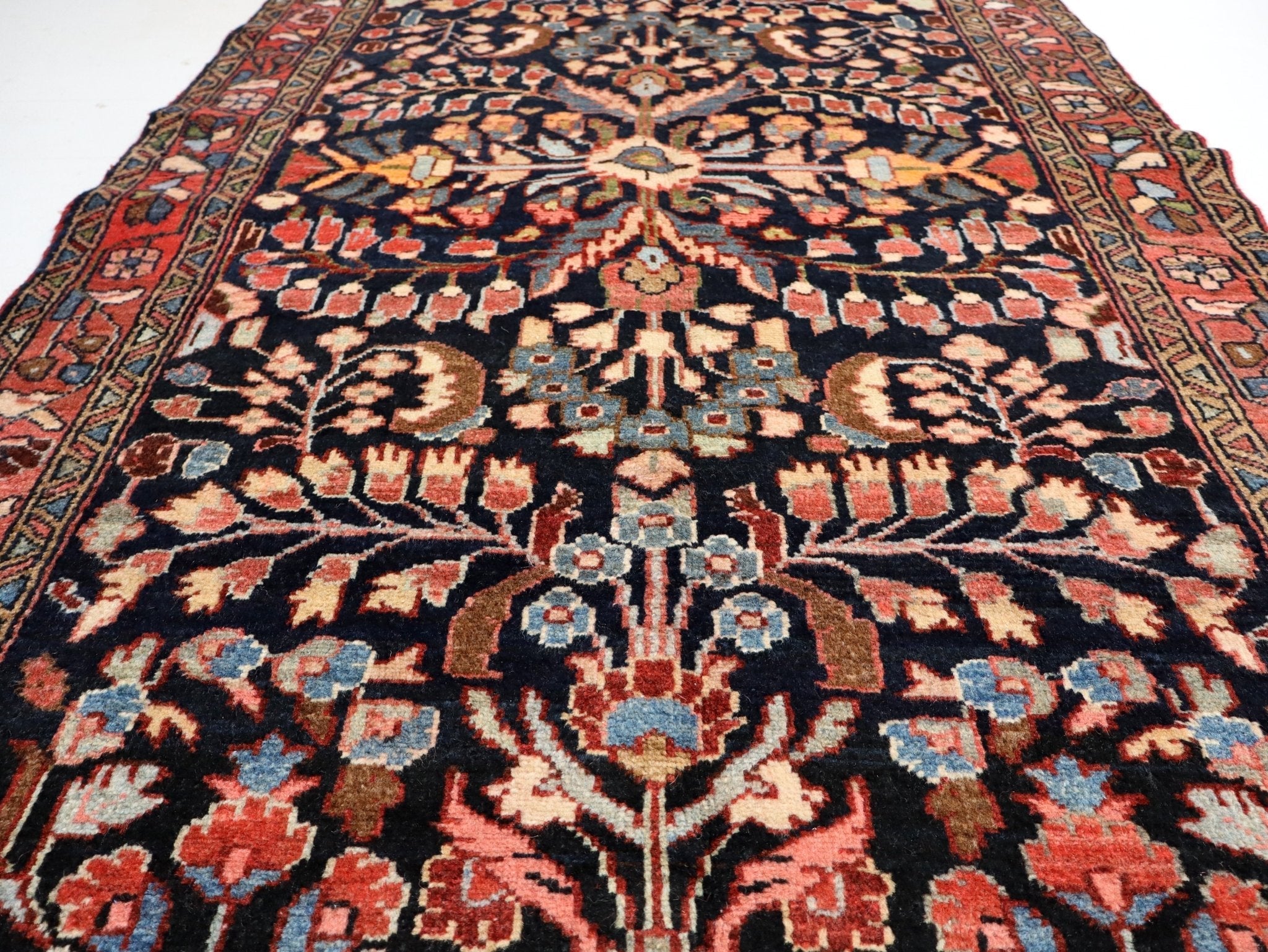 Runner rug with central medallion, navy base, coral and blue floral motifs