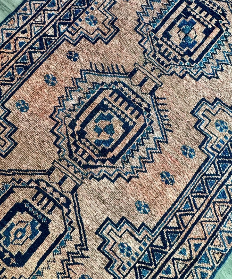 Persian Luri-style rug close-up with beige texture and navy-blue square medallions