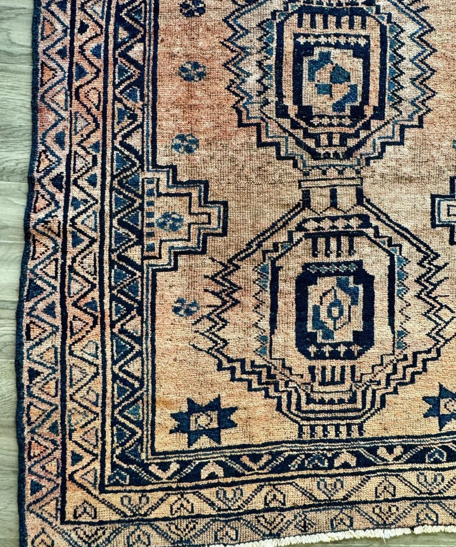 Persian Luri-style rug with beige base and dark navy geometric medallions