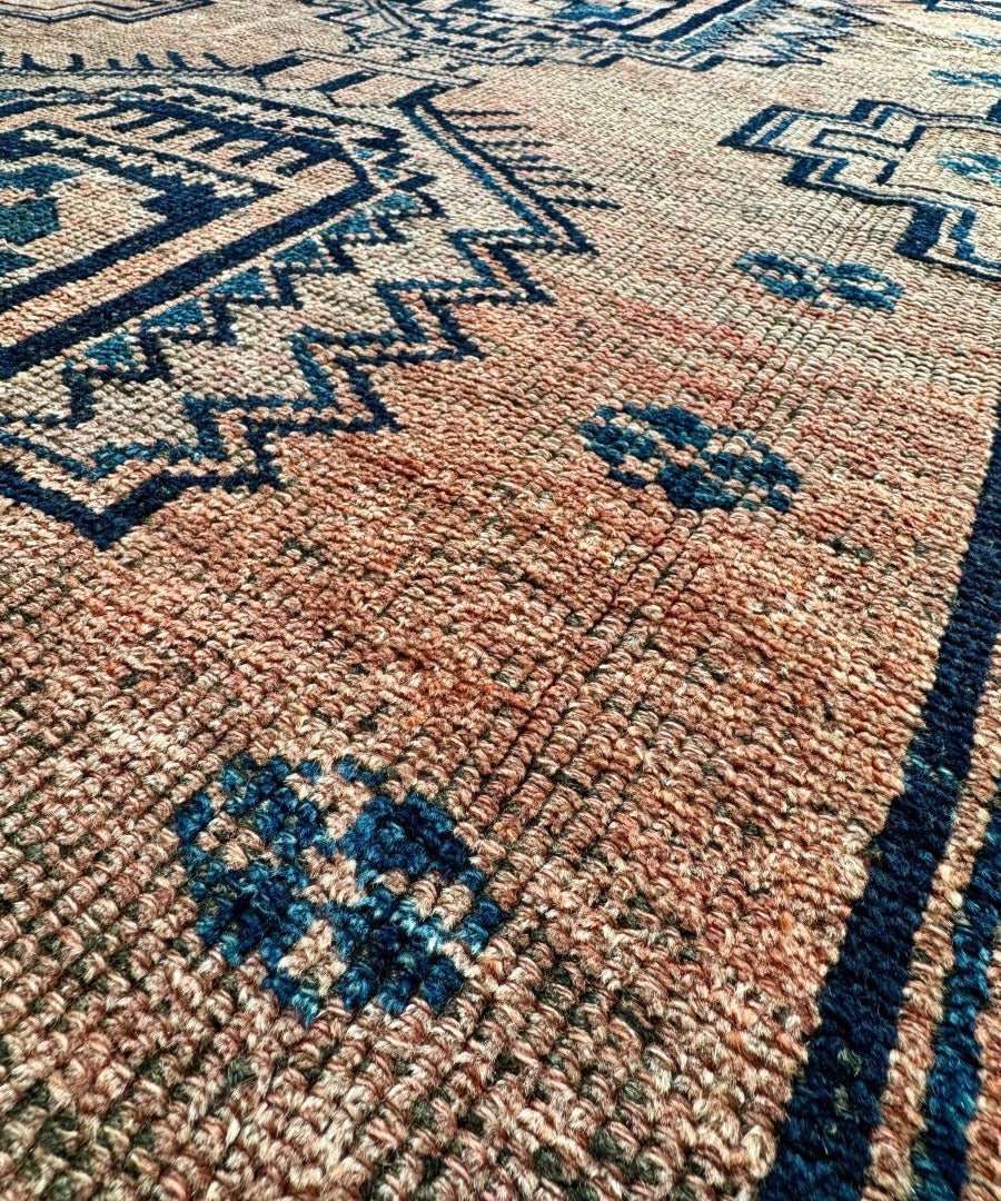 Persian Luri-style rug close-up with rust-beige weave and navy-blue pattern lines