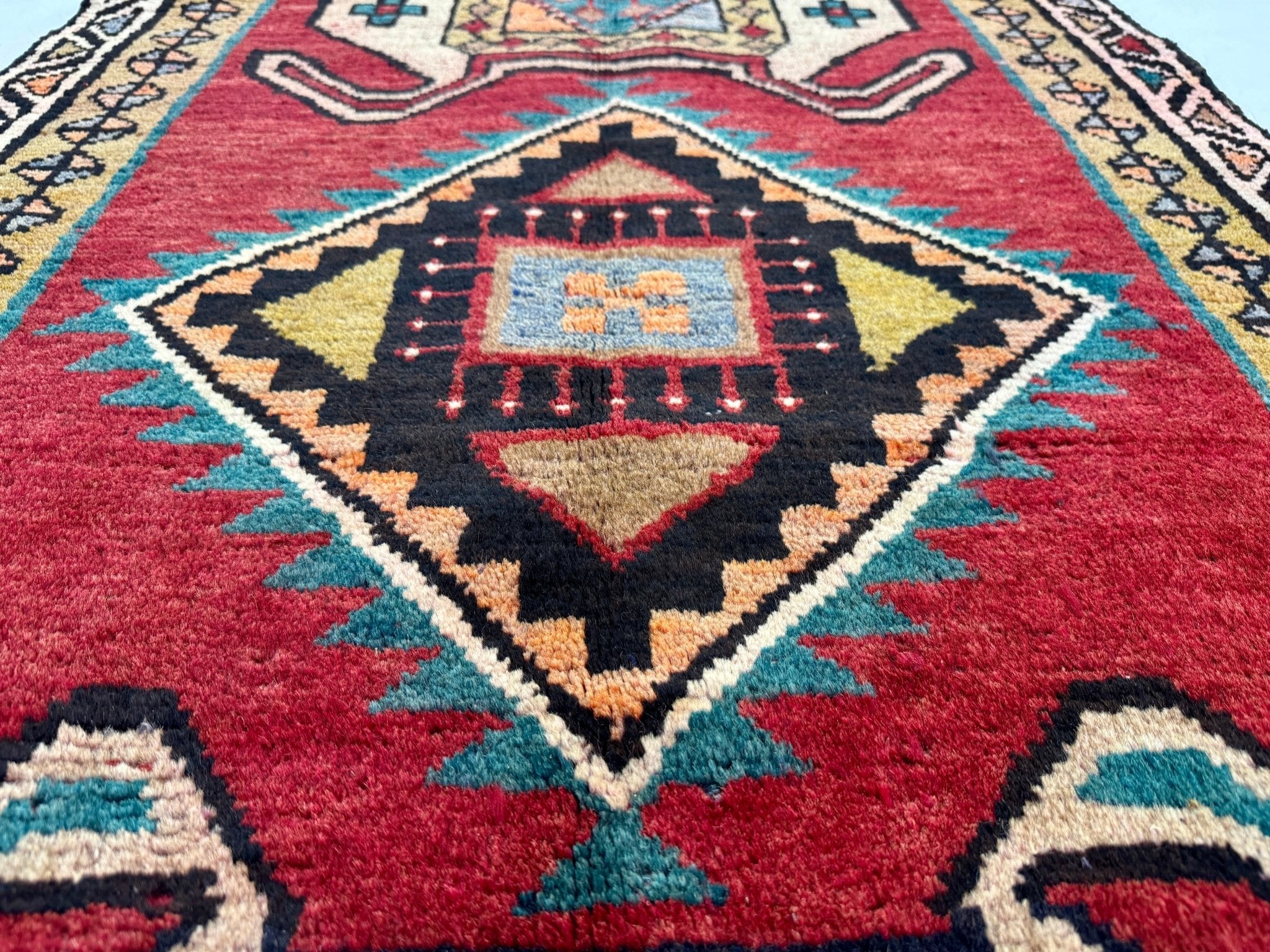 Persian Luri runner rug diamond medallion pattern on deep red background