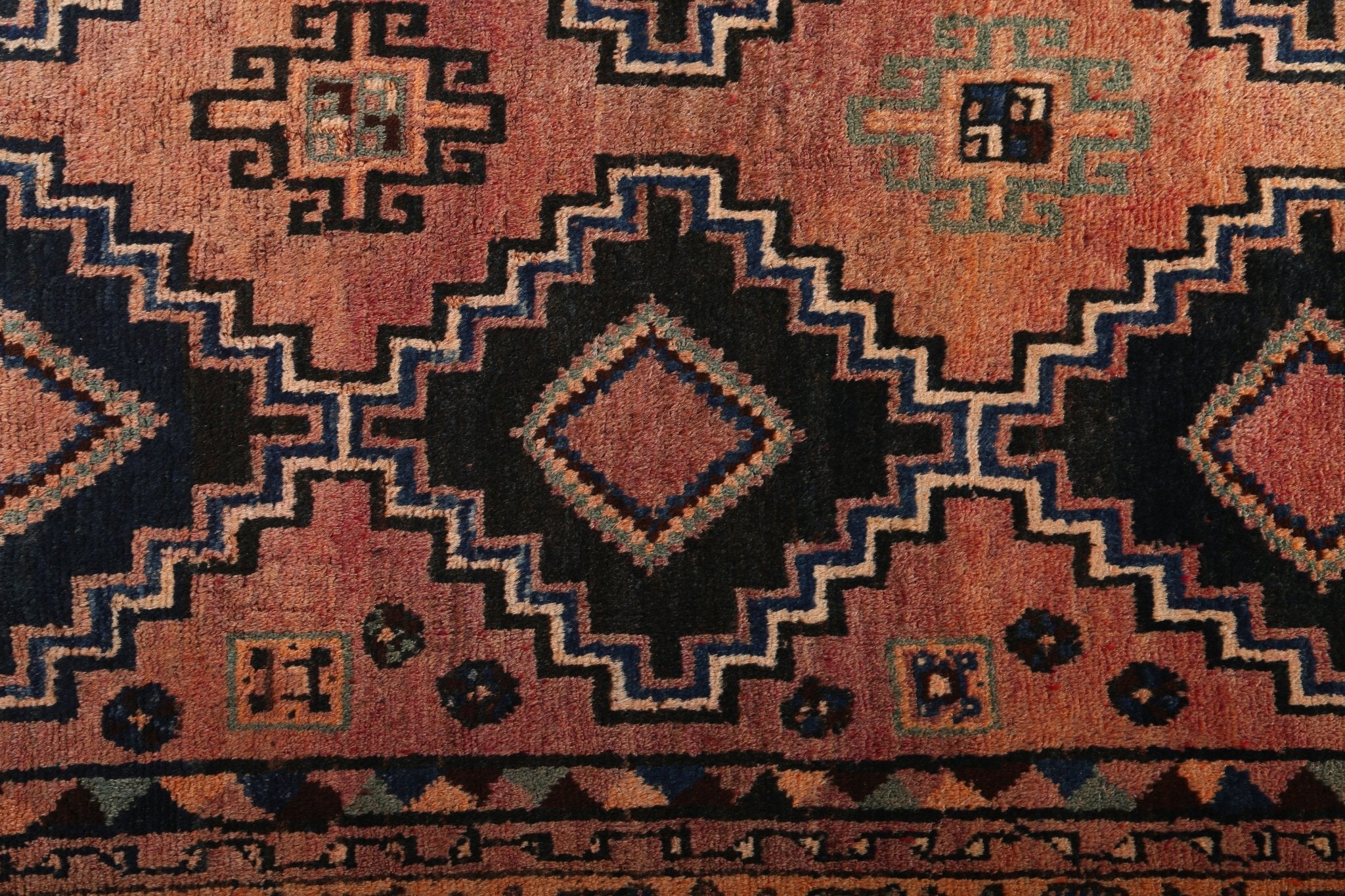 Persian Luri runner rug with rust orange field and navy geometric medallion pattern