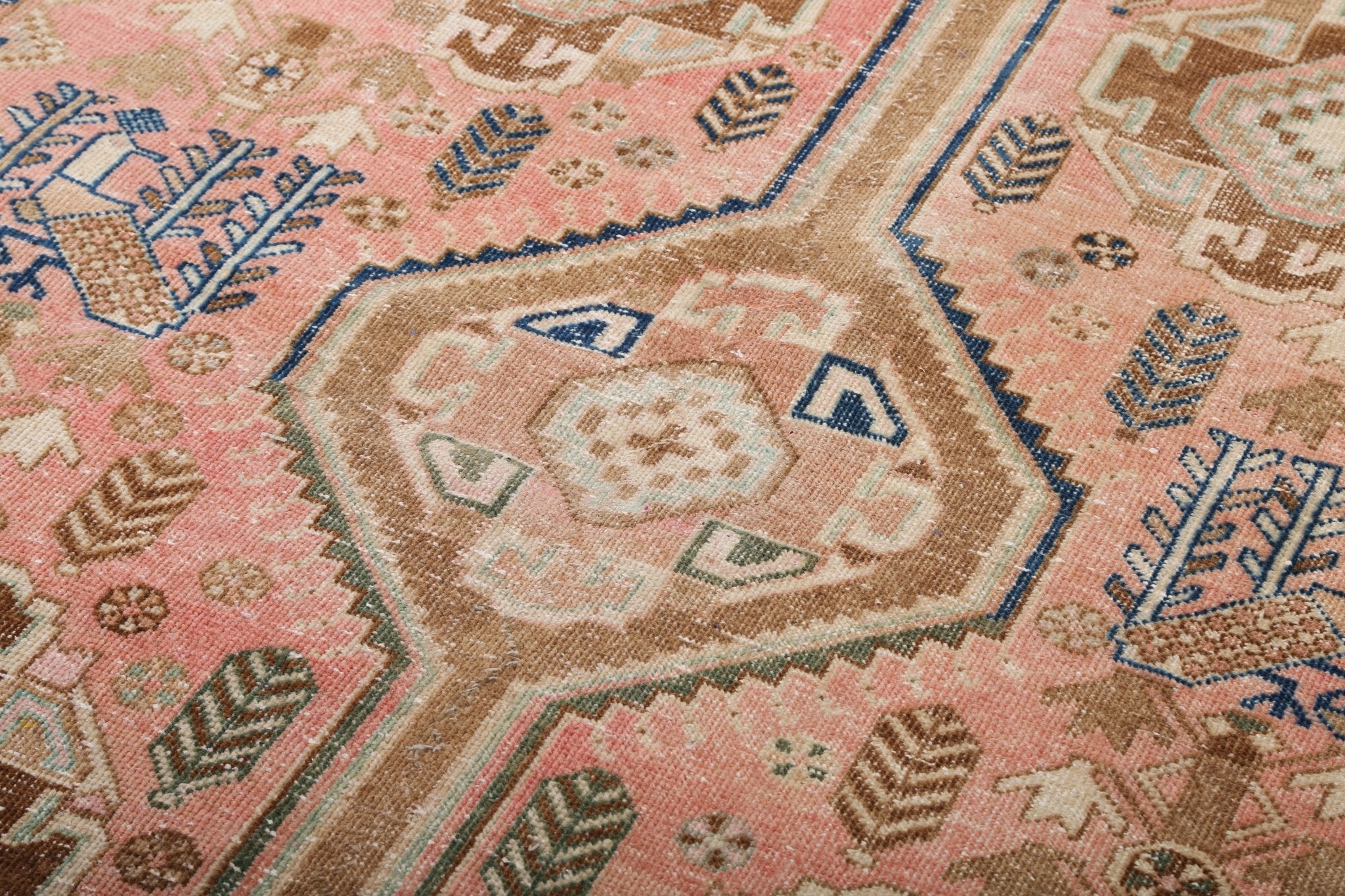Persian Mahal rug close-up showing large rosette medallion in pink, tan, and blue