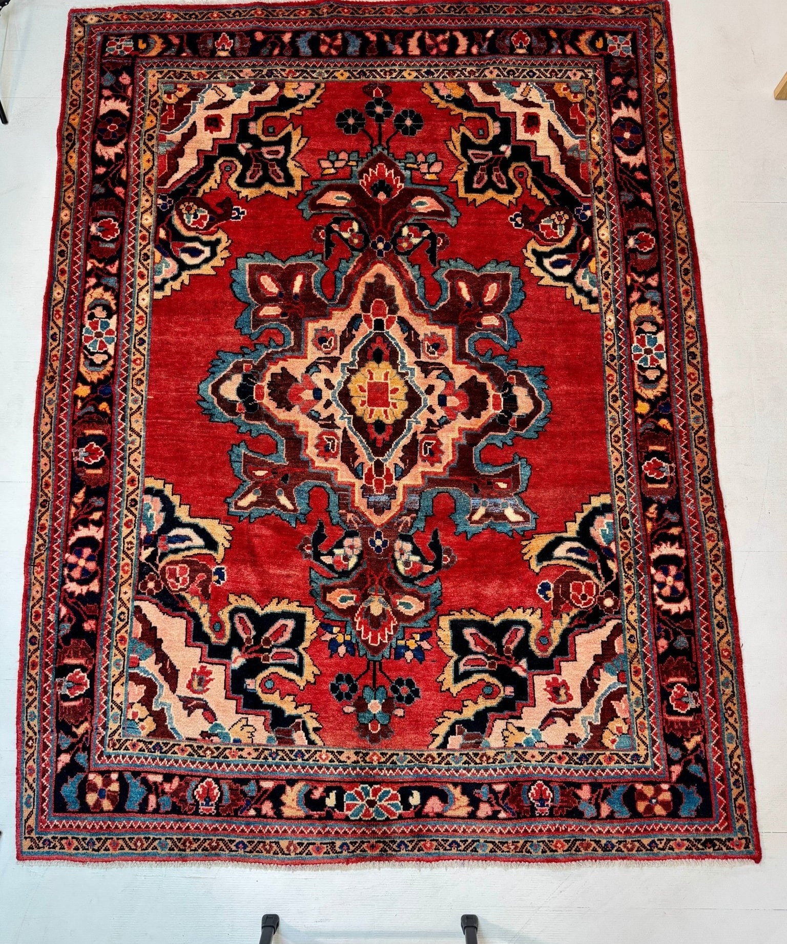 Persian Mahal area rug with red central medallion, blue floral corners, and ornate border