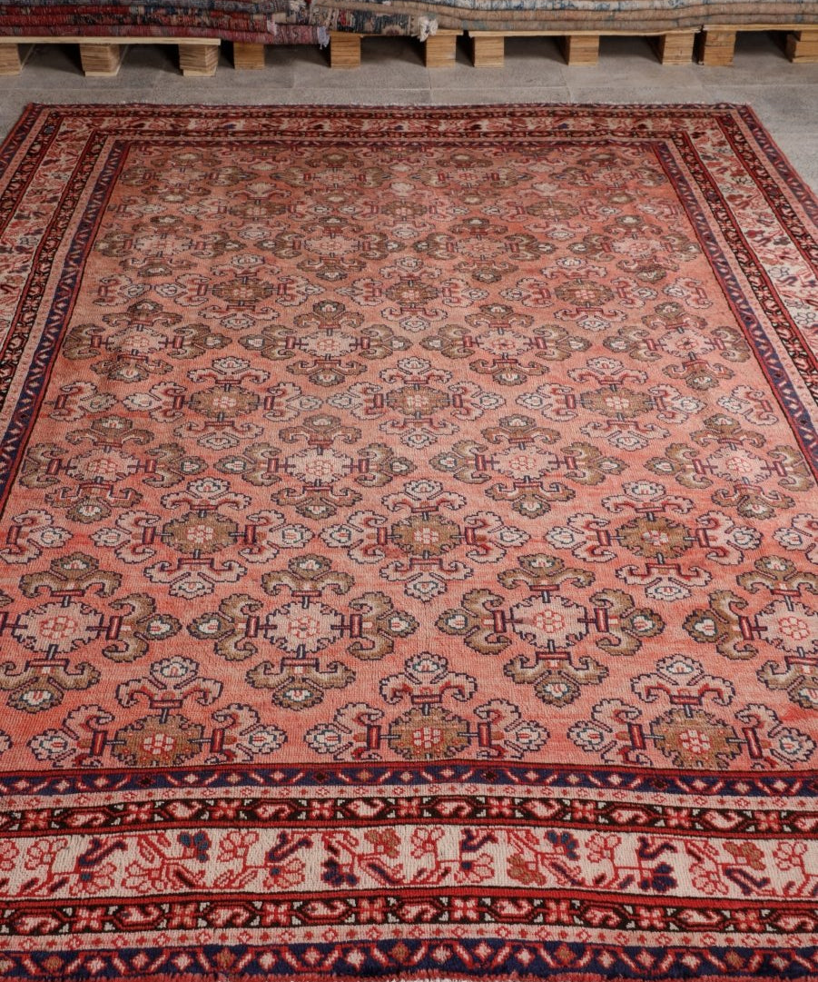 Persian Mahal rug with rust-red field, ornate medallions, and navy border stripes