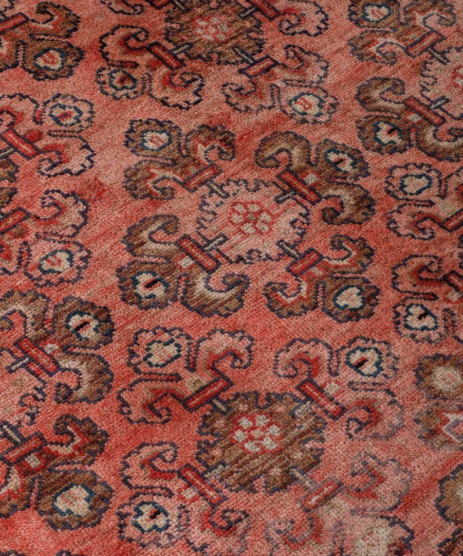 Close-up of Persian Mahal rug pattern with rust-red background and navy motifs