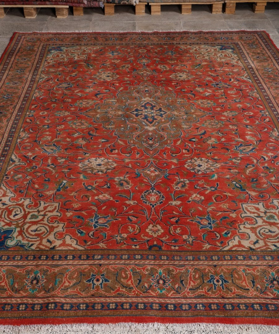 Red Persian-style rug with ornate medallion center and navy border patterns