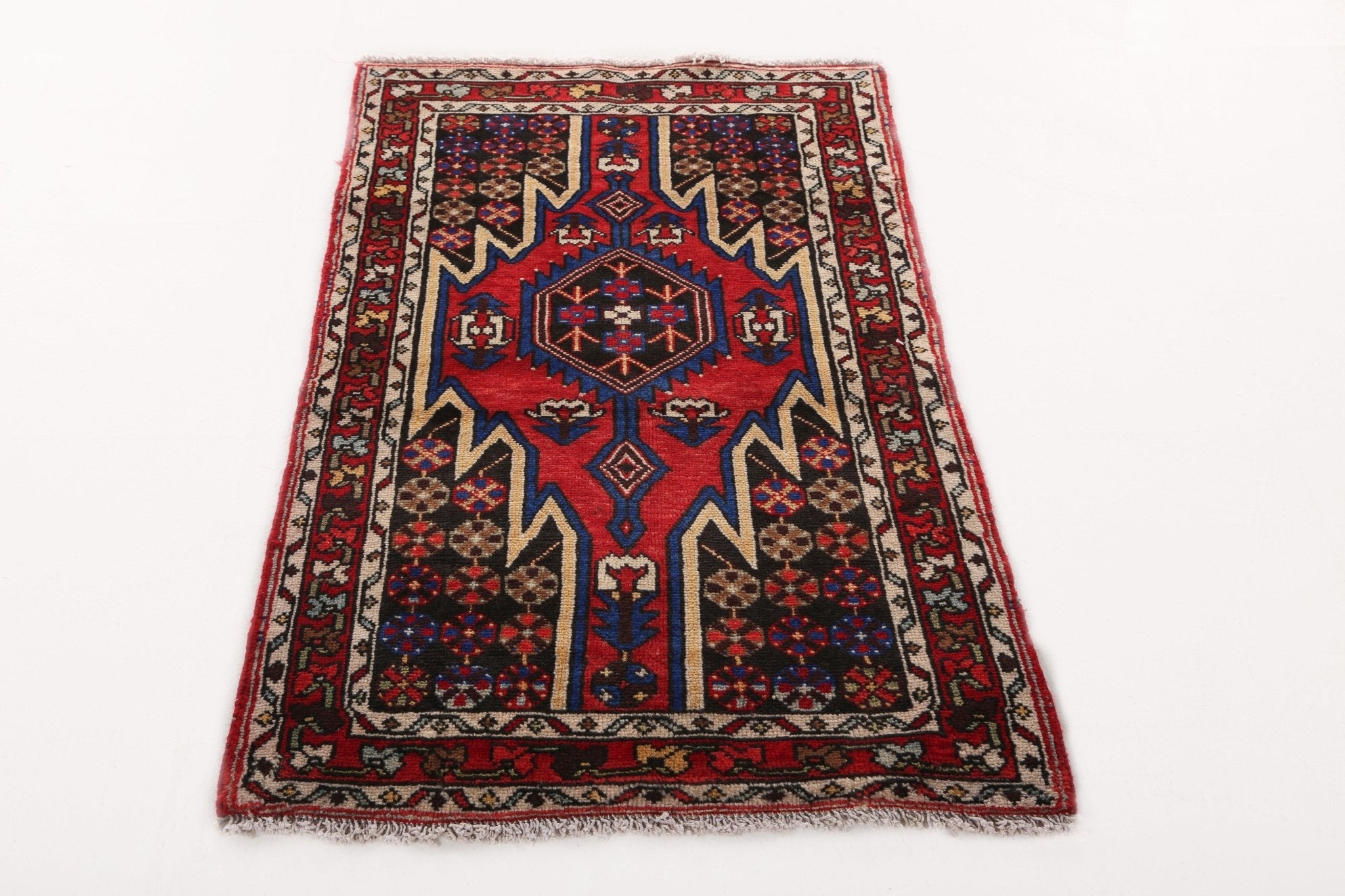 Persian Mazlaghan rug with repeating side panels and central blue star motif on red.