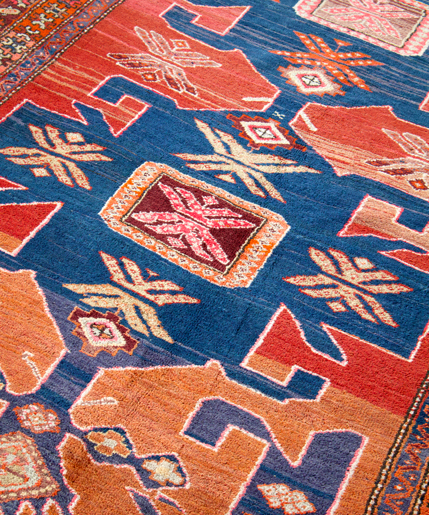 Persian Arshaq meshkin rug detail with blue field and rust-colored geometric accents
