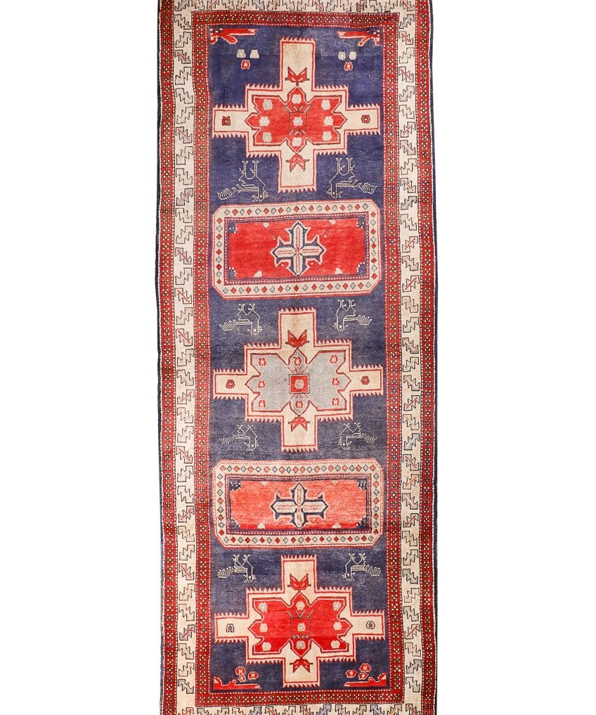 Persian runner rug with navy field, red border, and geometric medallion motifs.
