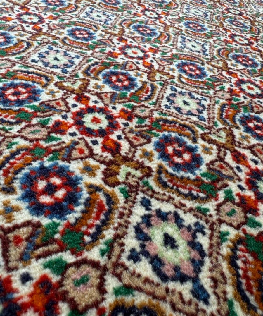Persian-style rug close-up of repeating circular motifs with blue, red, green, and beige