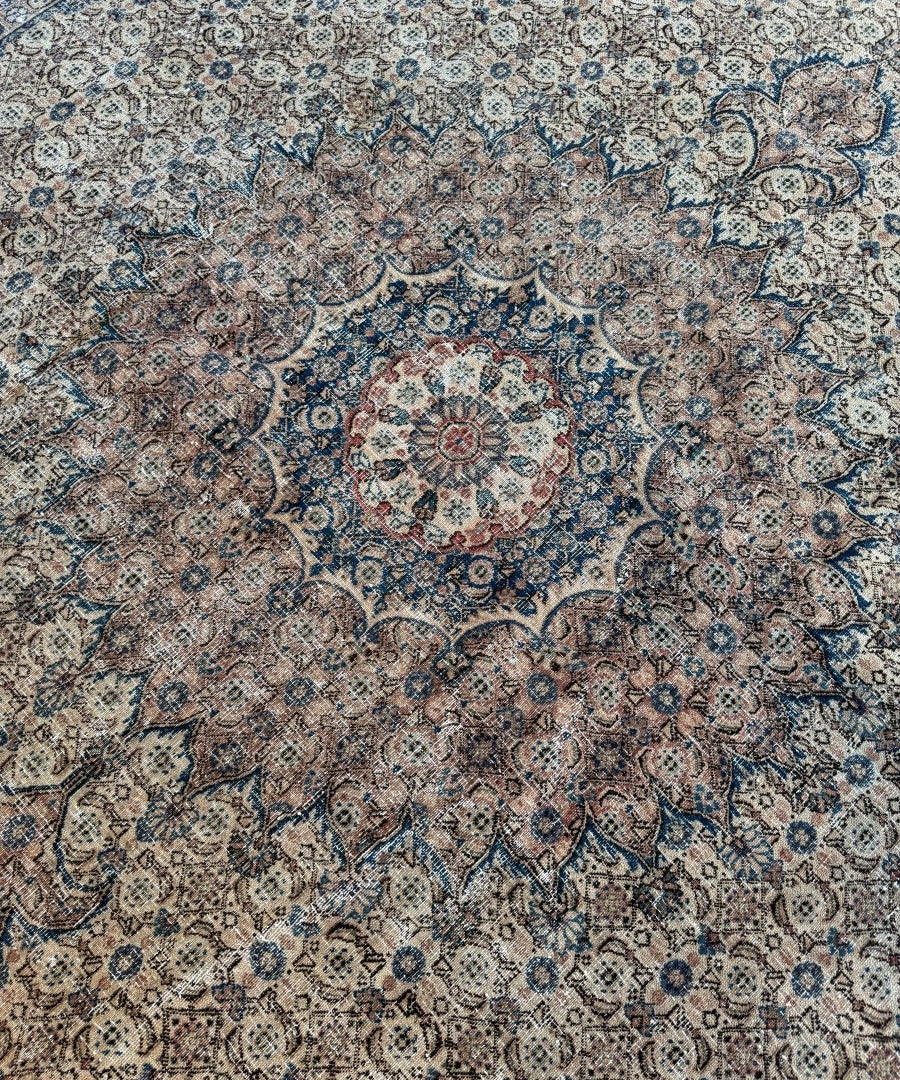 Persian-style rug close-up with blue and beige floral medallion pattern