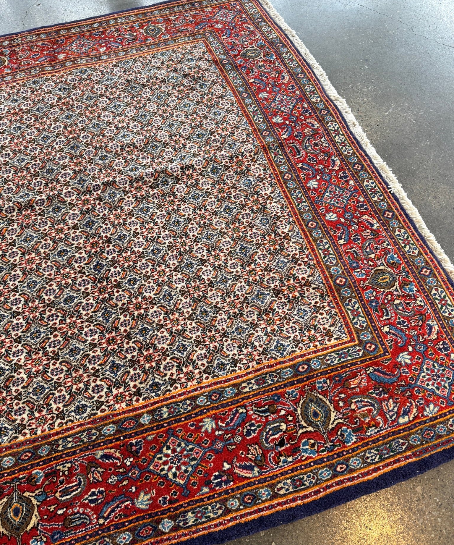 Persian Moud rug with red outer border, cream field, and multicolor medallion details.