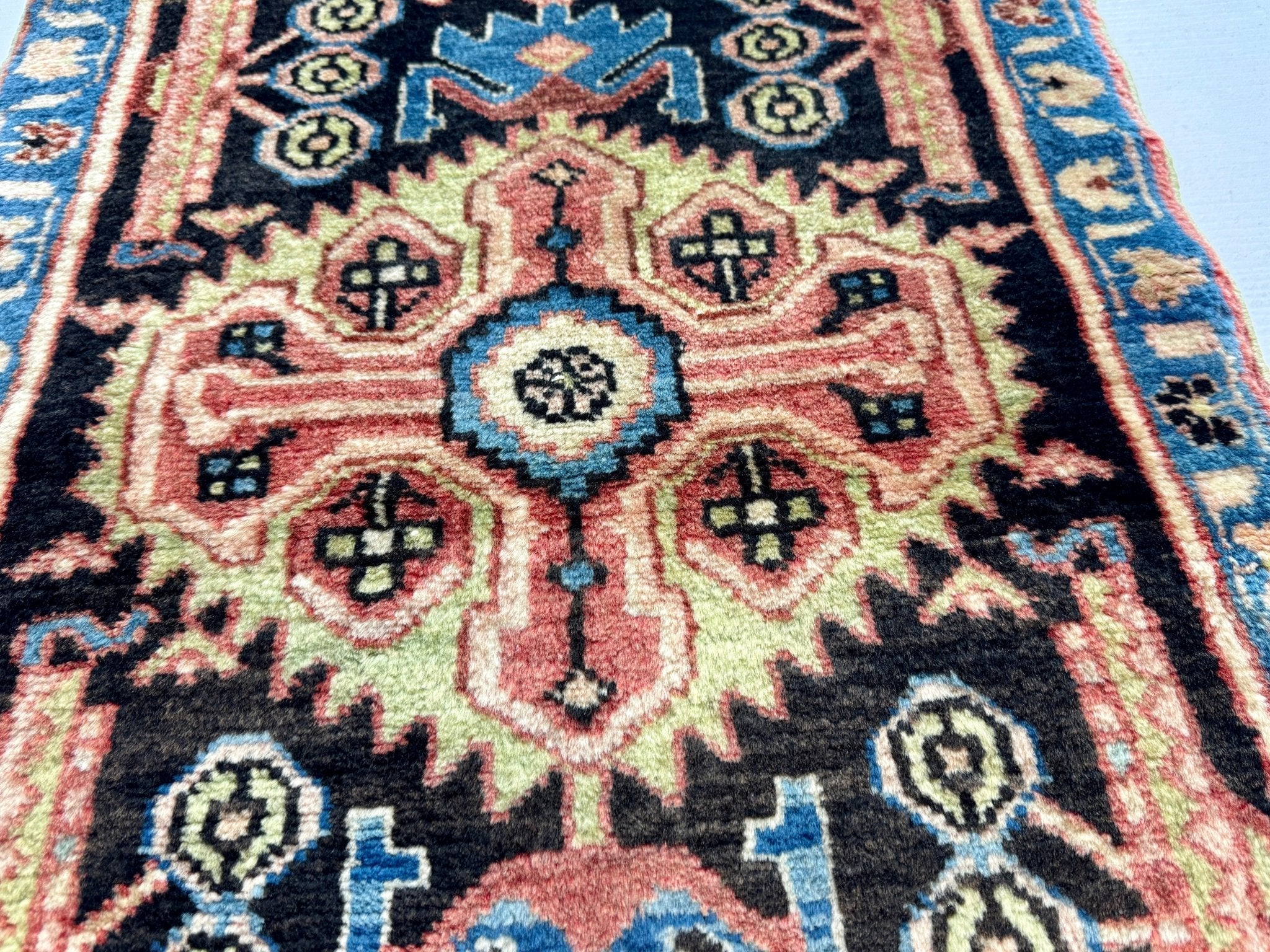 Persian Nahavand rug close-up of central rosette with black, cream, and blue pattern