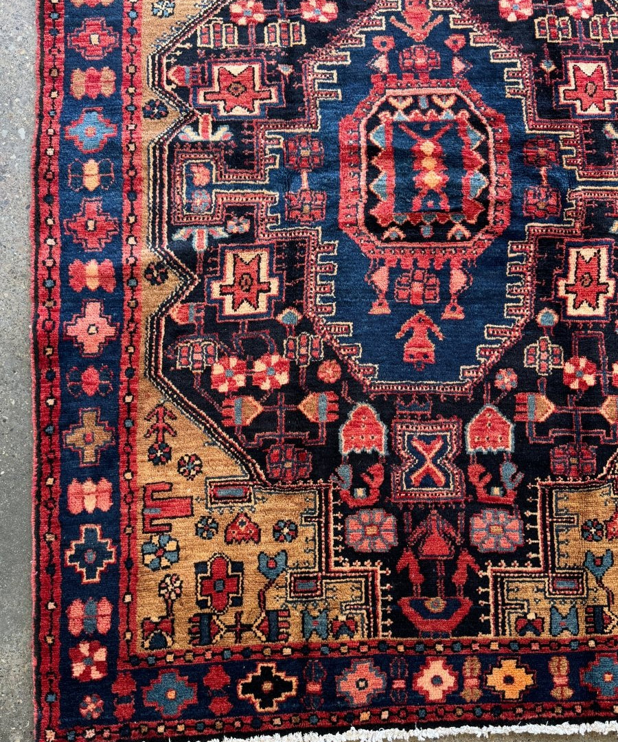 Navy rug close-up with red medallion, star and cross motifs, and patterned borders.