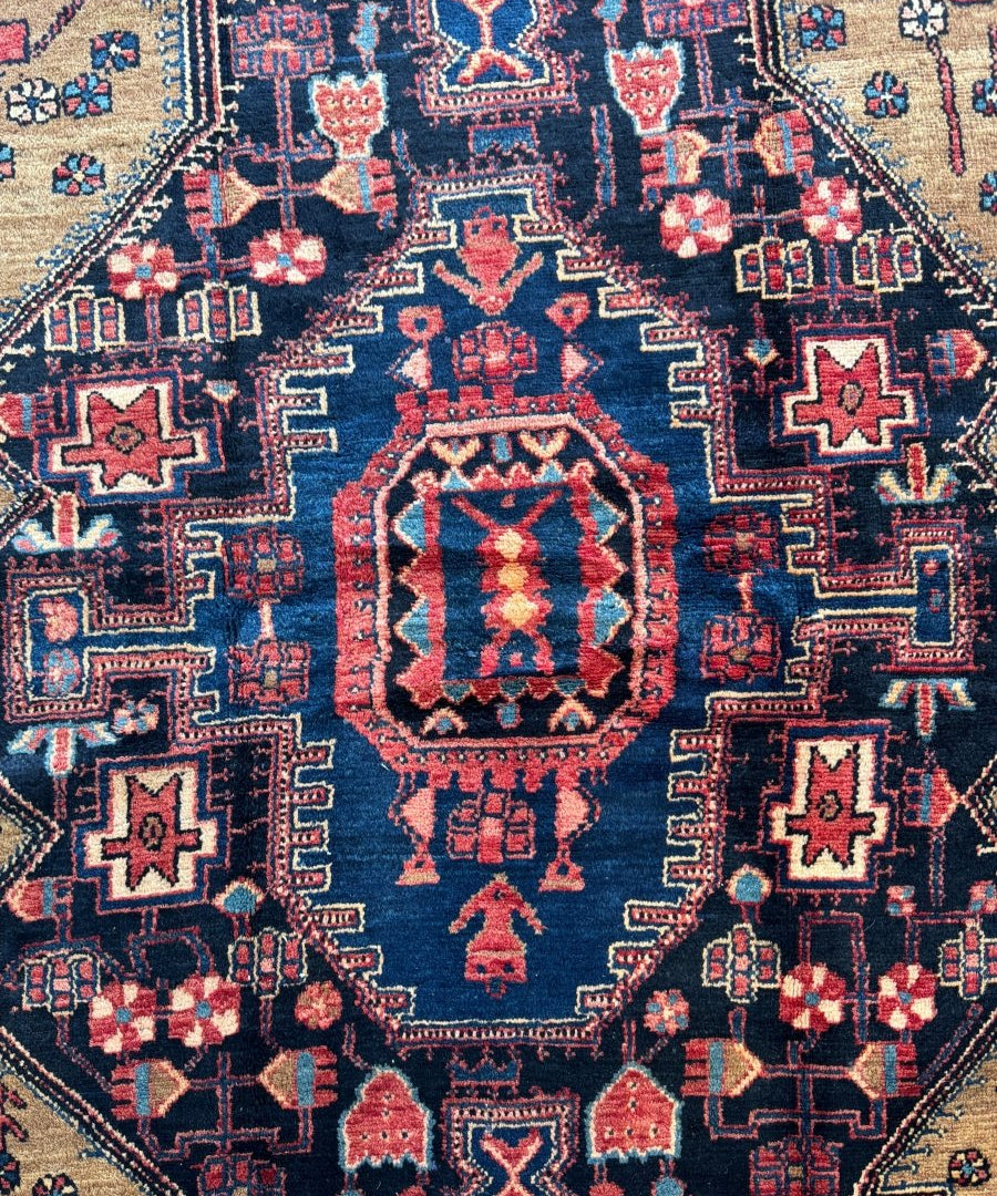 Navy rug detail with red central medallion and small geometric star motifs across field.
