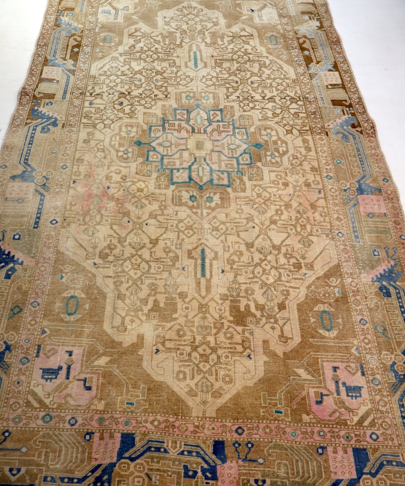 Persian rug full view with cream base, blue accents, and central geometric medallion