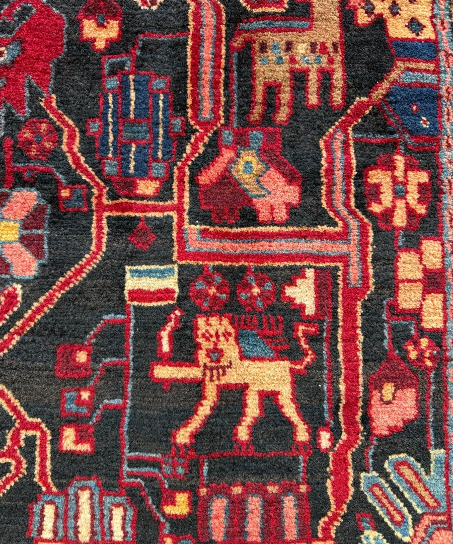 Persian area rug close-up showing red and cream animal motifs on a navy field