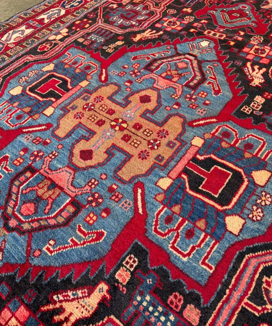 Persian area rug close-up with navy, red, and light blue geometric motifs