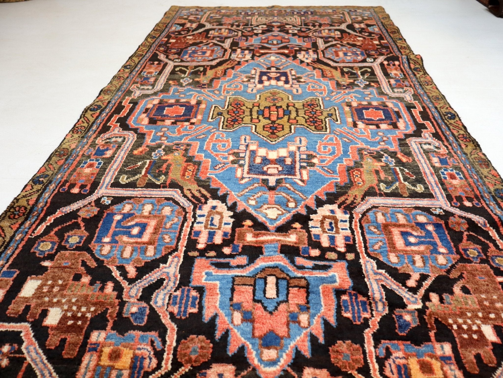 Persian runner rug close-up with central blue medallion and dark red patterned field