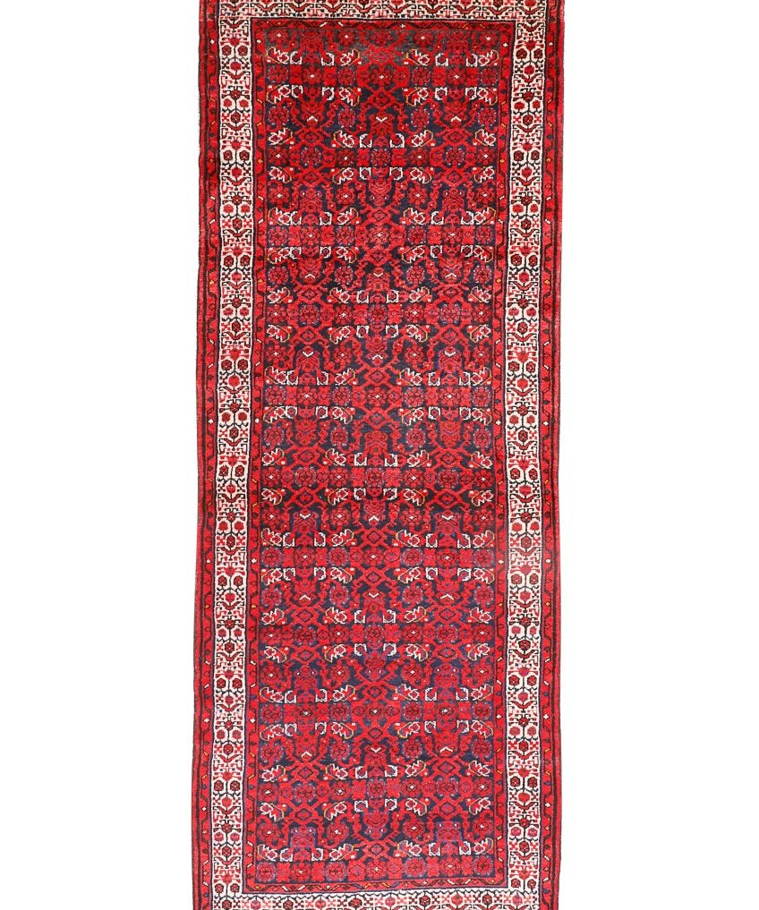 Persian runner rug studio view with dark red central motif, cream frame, and thin fringe.