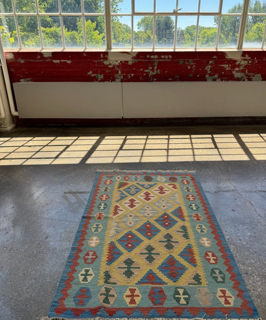 Kilim rug with geometric diamond motifs in blue, red, beige; short fringed edge