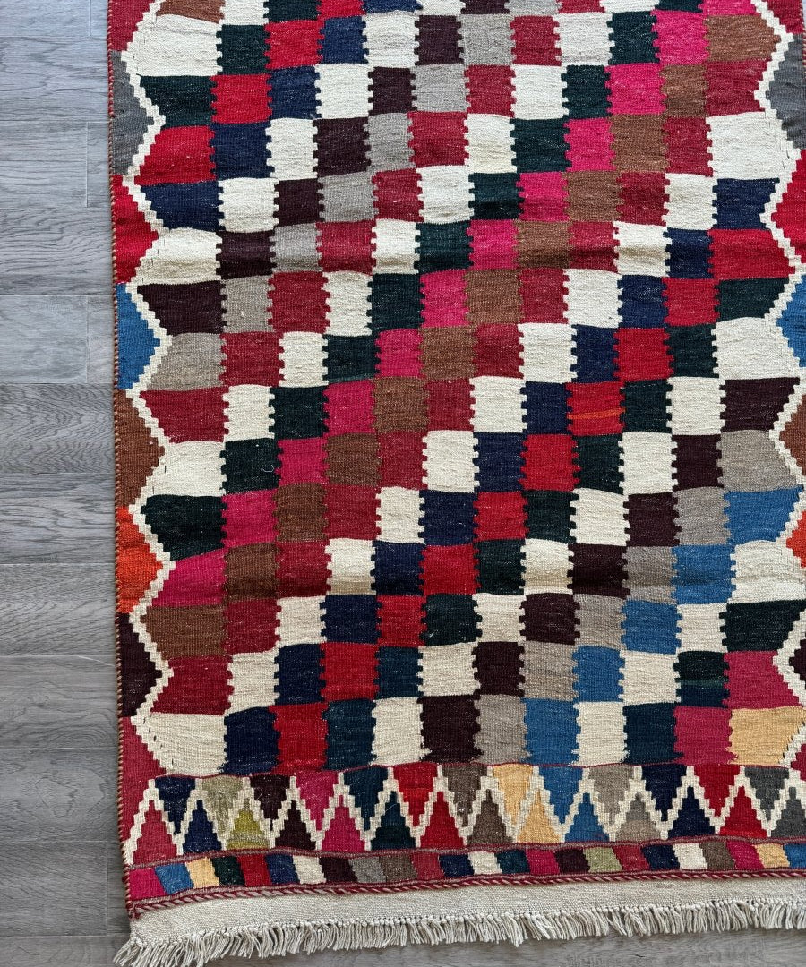 Persian Qashqai kilim rug with geometric check pattern and zigzag border, fringed edge