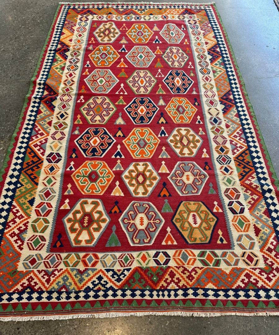 Persian Qashqai kilim rug featuring diamond motifs in red, cream, green and blue
