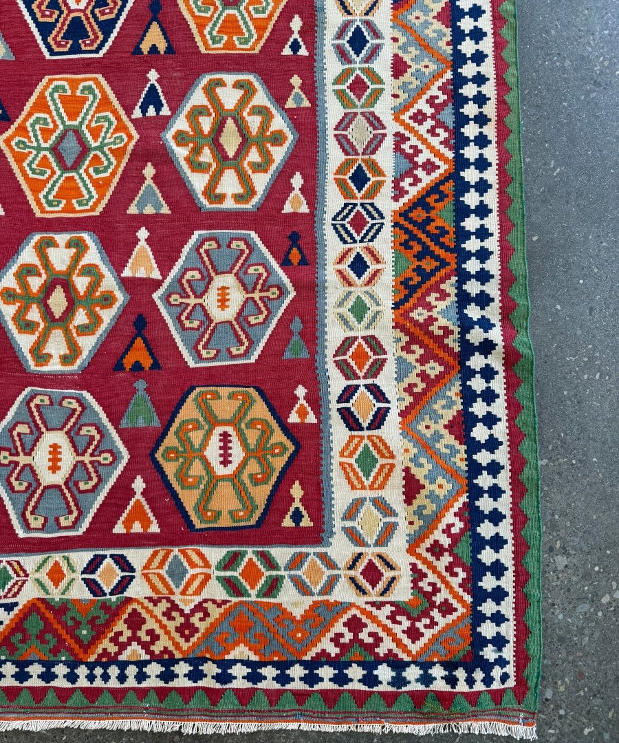 Persian Qashqai kilim rug corner detail with blue, red and green geometric motifs