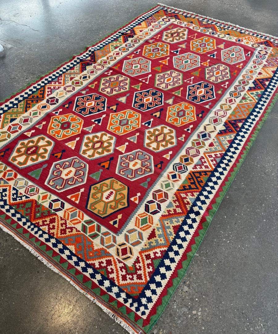 Persian Qashqai kilim rug with red center field and cream border with geometric shapes