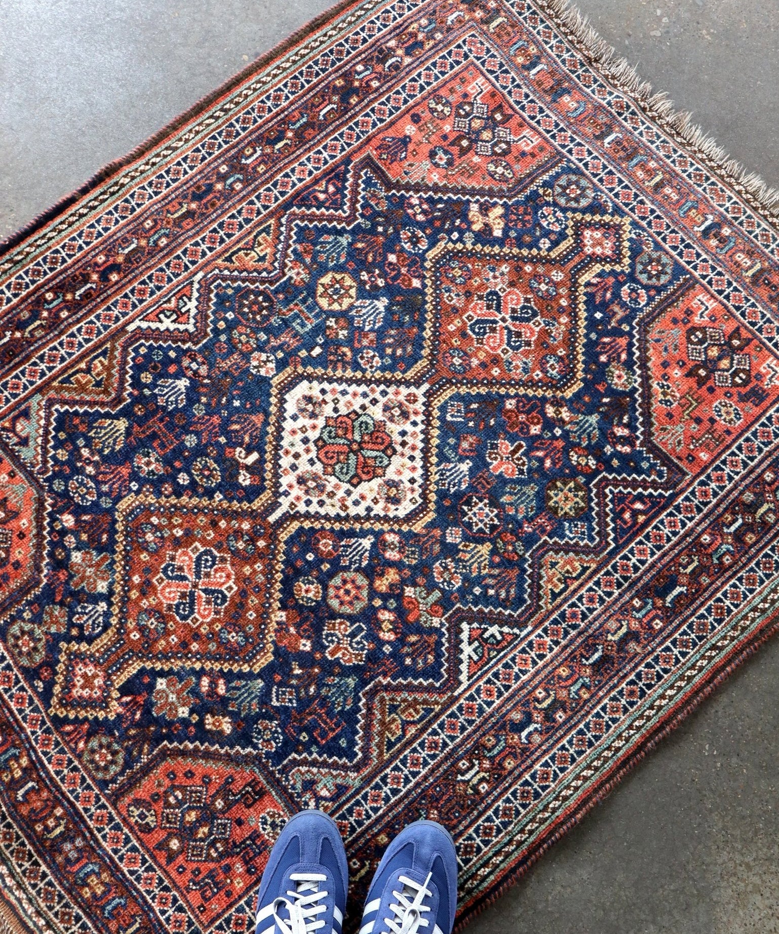 Persian Qashqai-style rug corner detail with navy, red, and ivory diamond motifs