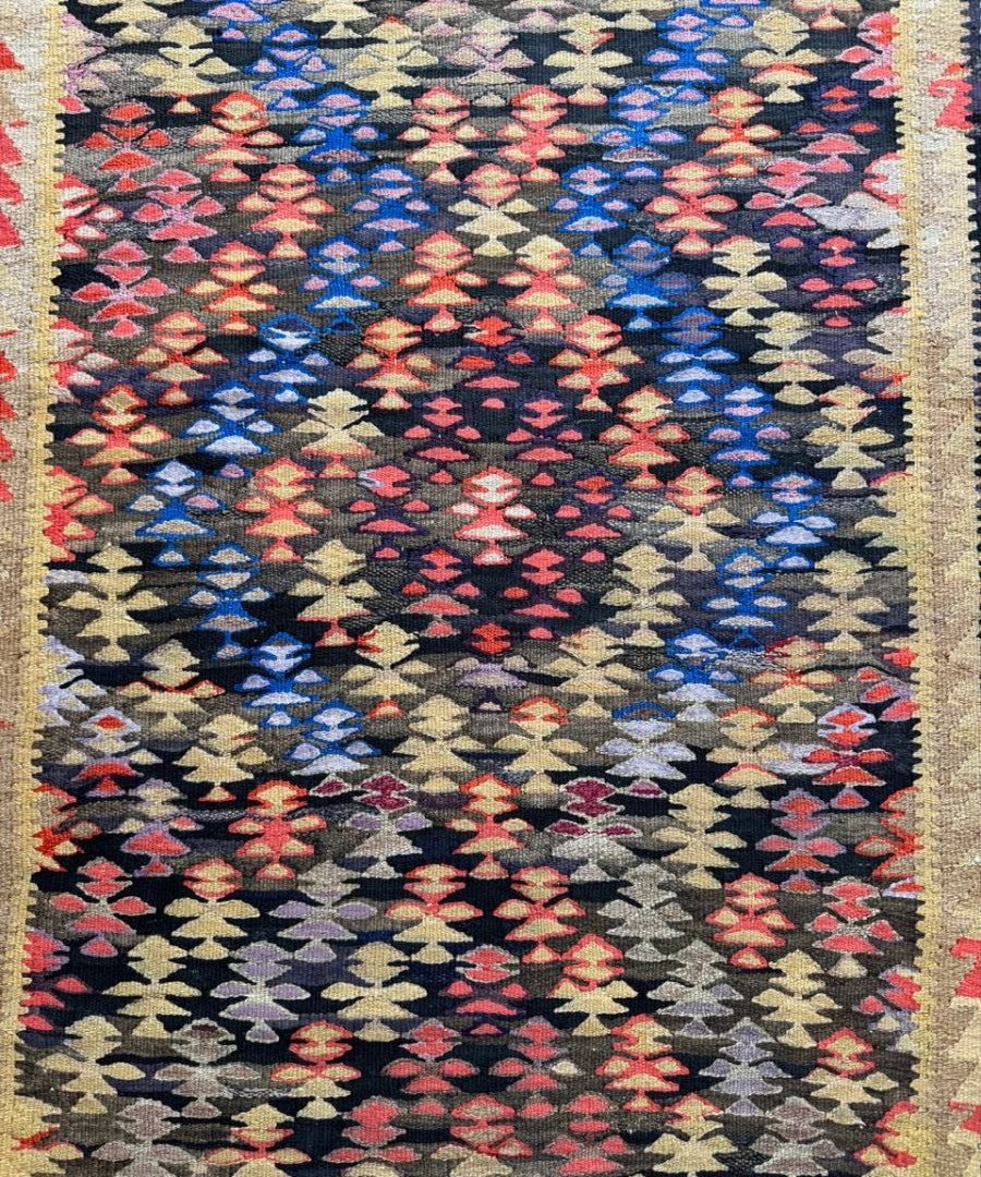 Kilim runner rug with charcoal ground and red, blue, pink, and cream patterns