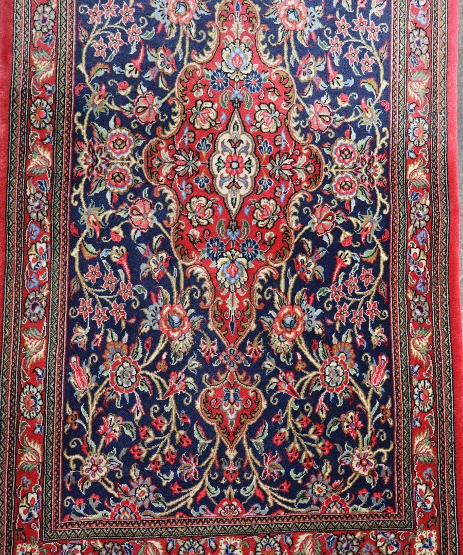 Persian Qom Kork wool runner rug with red, navy, and floral medallion pattern