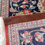 Navy Persian runner rug corner with fringe and red border edging