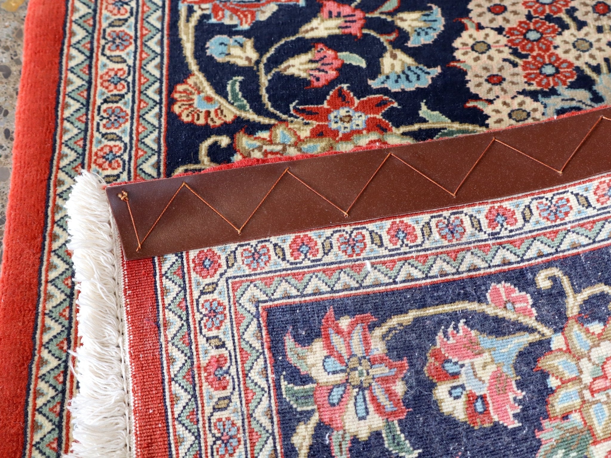 Navy Persian runner rug corner with fringe and red border edging