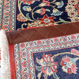 Navy Persian runner rug corner with fringe and red border edging