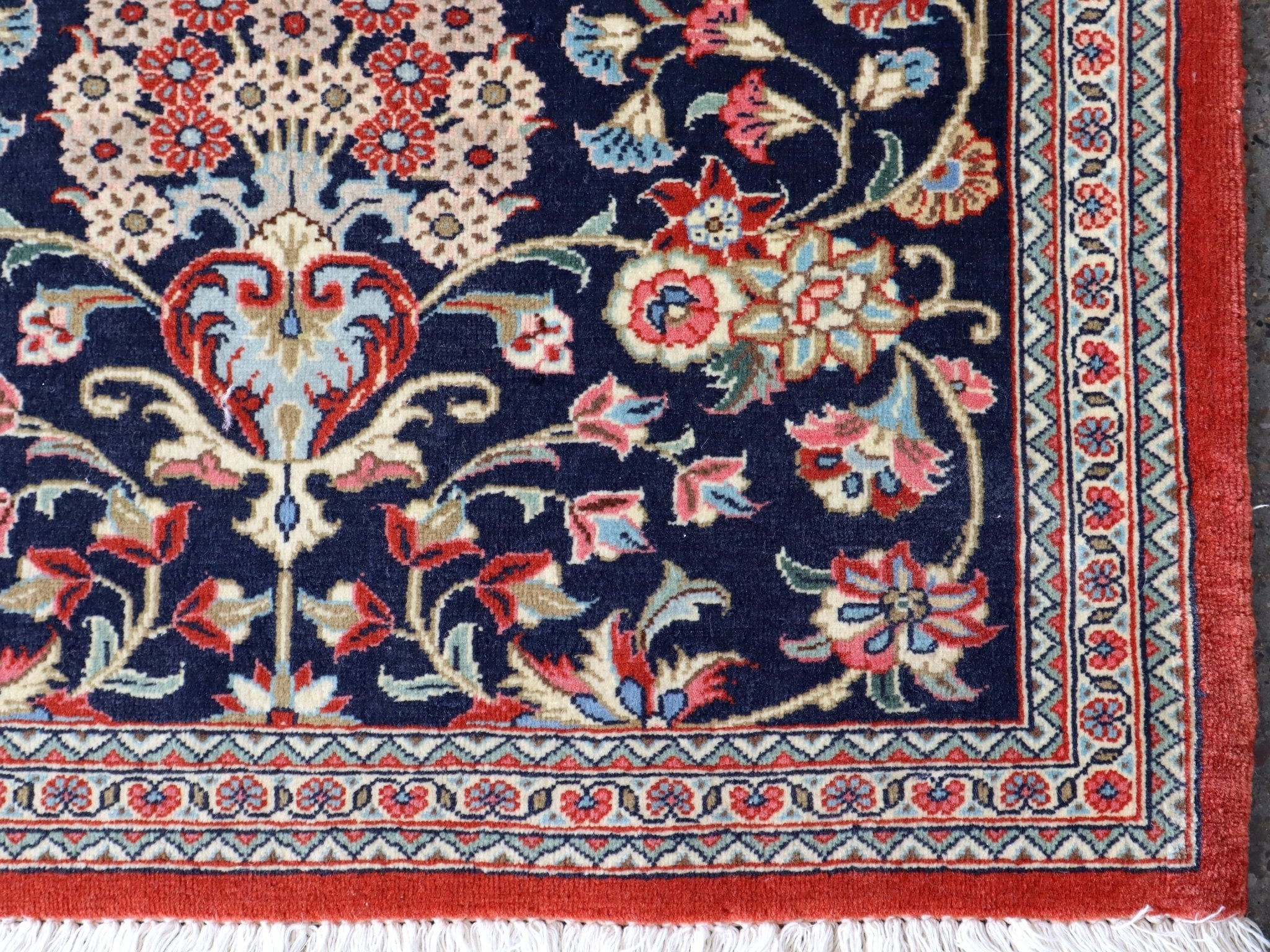 Persian Qom runner rug close-up of border: navy, cream and red floral panel