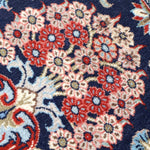 Persian Qom runner rug close-up: navy field filled with red and cream floral diamonds
