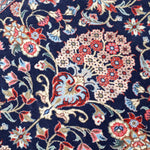Persian Qom runner rug close-up: navy field with multicolor floral motifs and vines