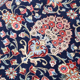 Persian Qom runner rug close-up: navy field with multicolor floral motifs and vines