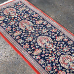 Navy Persian runner rug with red border and floral medallion pattern