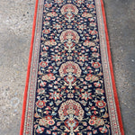 Persian Qom runner rug with navy floral medallion pattern and red border