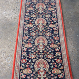 Persian Qom runner rug with navy floral medallion pattern and red border