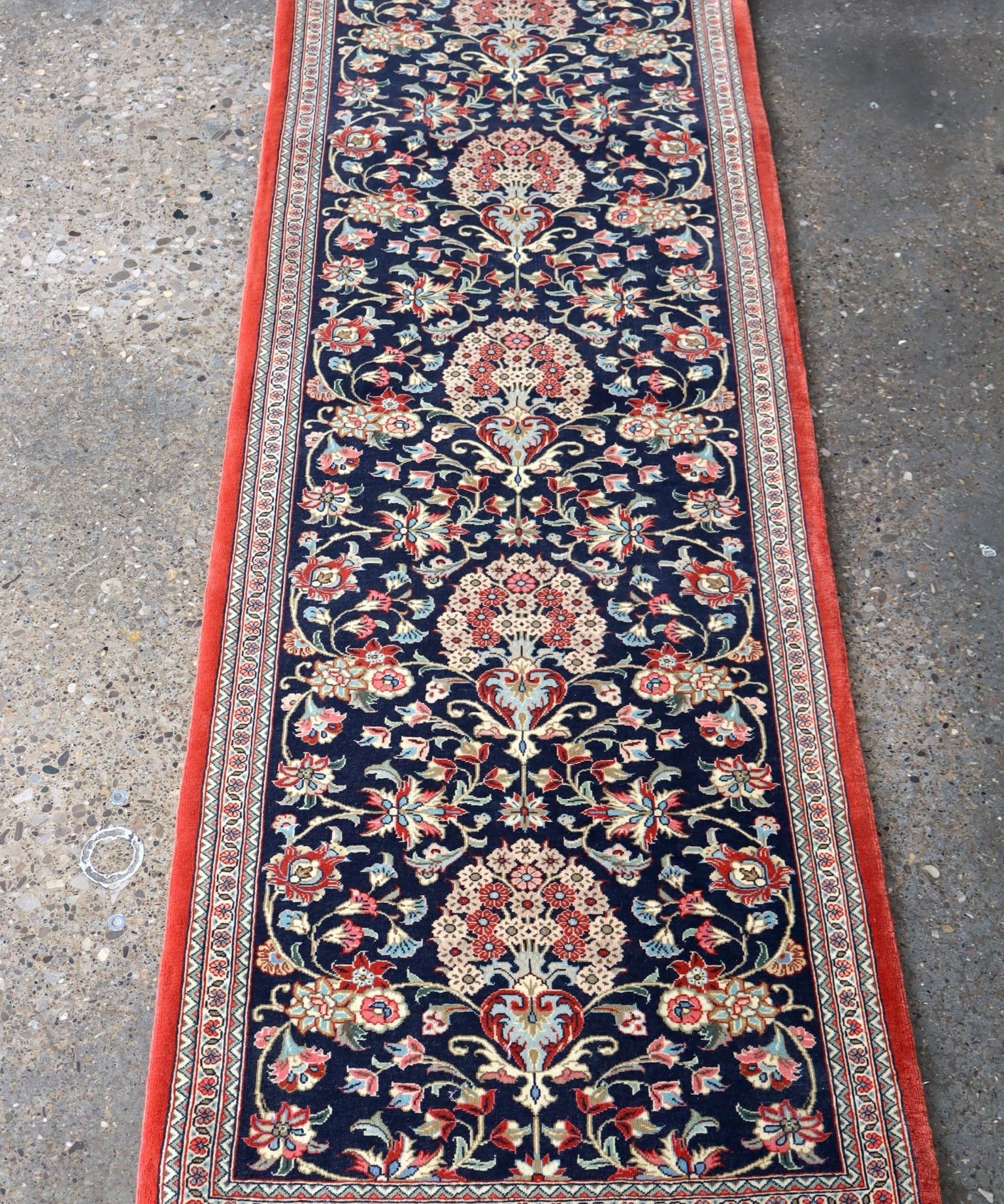 Persian Qom runner rug with navy floral medallion pattern and red border