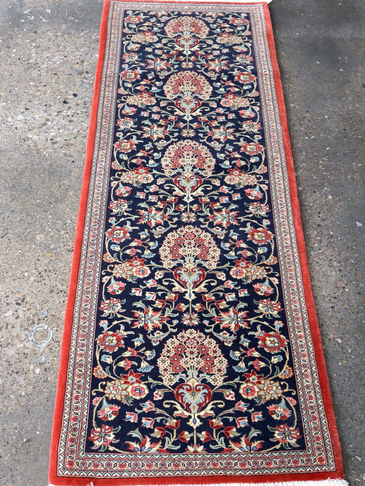 Persian Qom runner rug with navy floral medallion pattern and red border