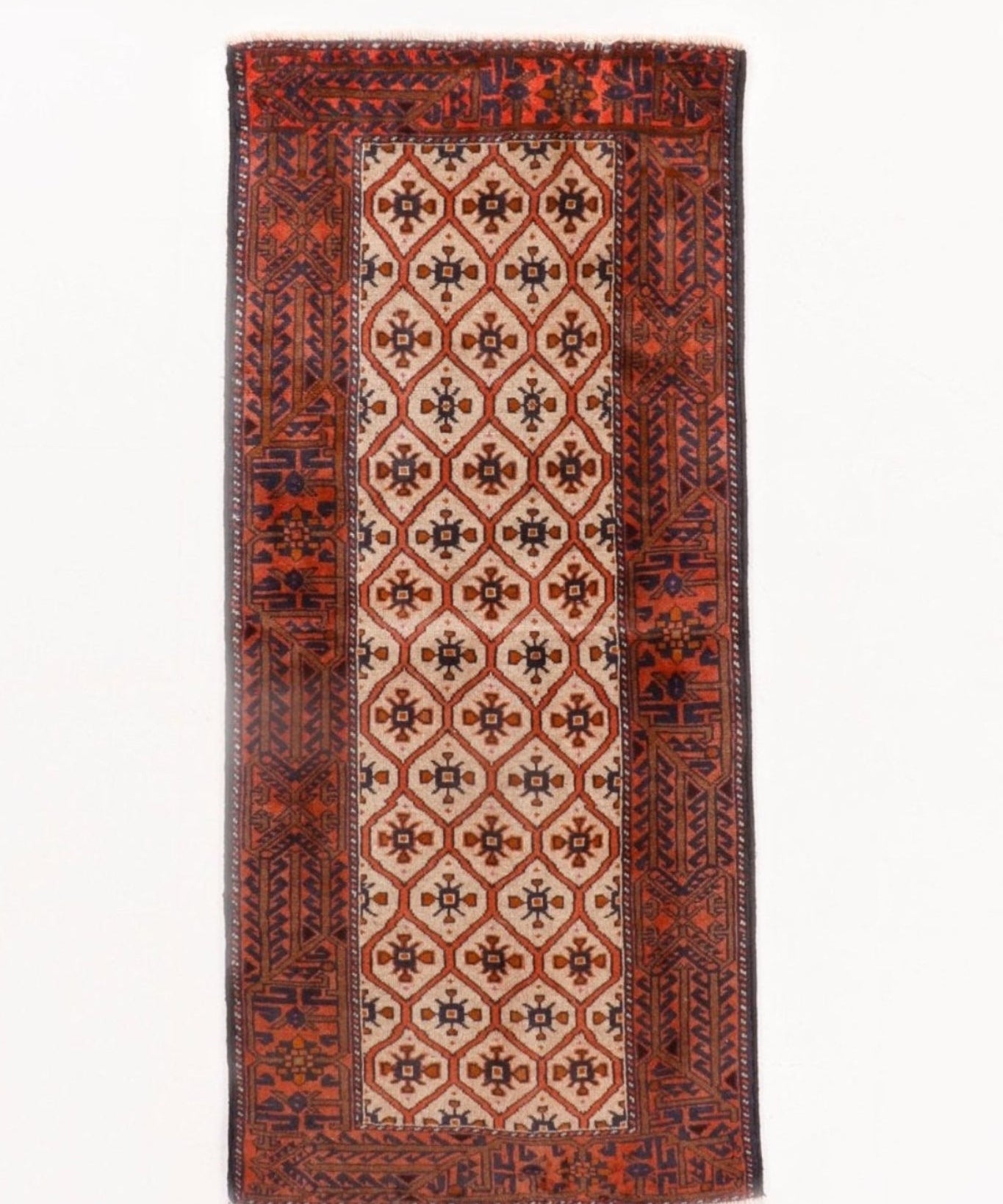 Persian rug with beige center medallions, terracotta border, navy and rust geometric motifs
