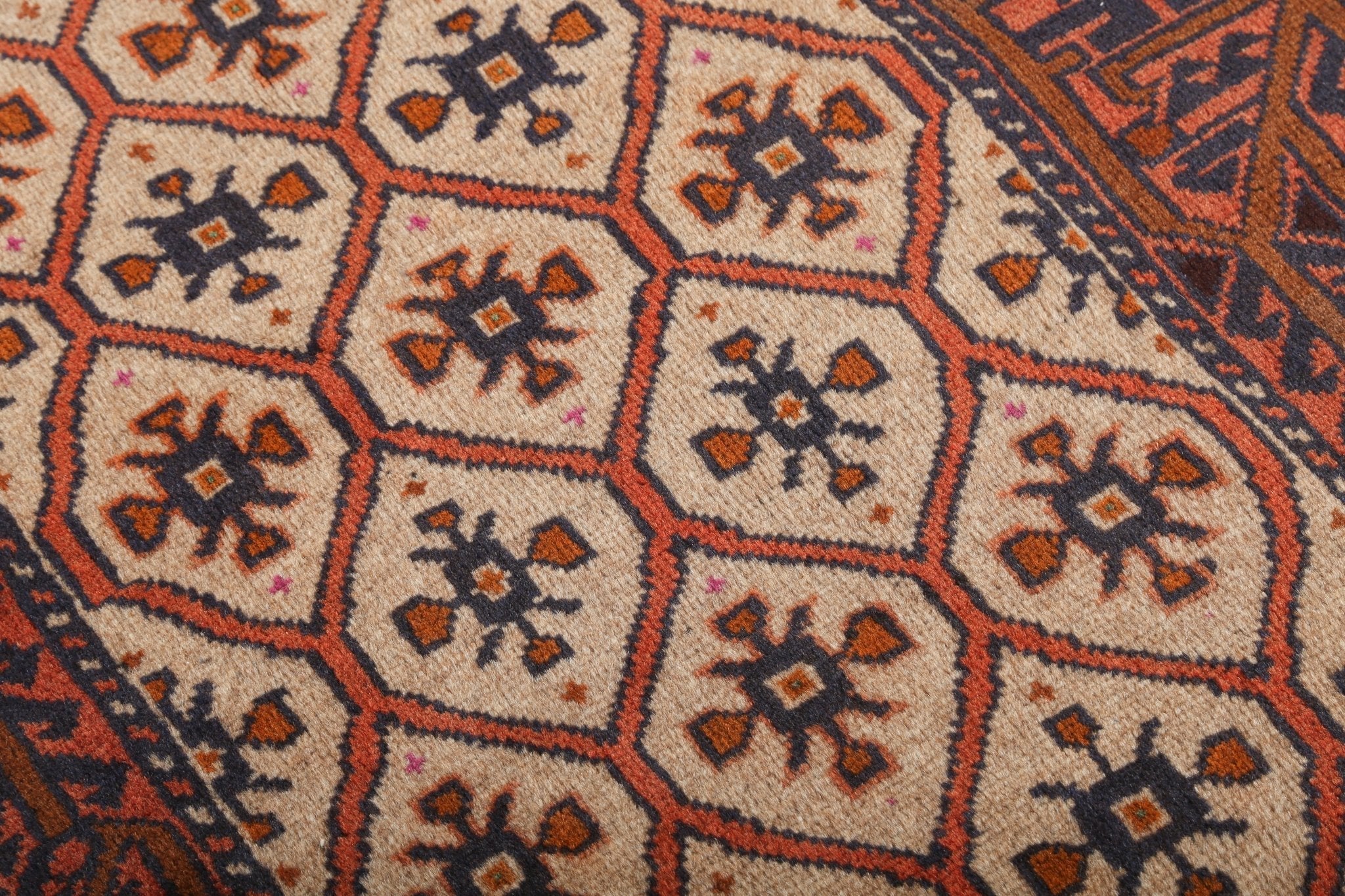 Persian Quchan Kurd rug with repeating hexagonal medallions in orange, navy, and cream