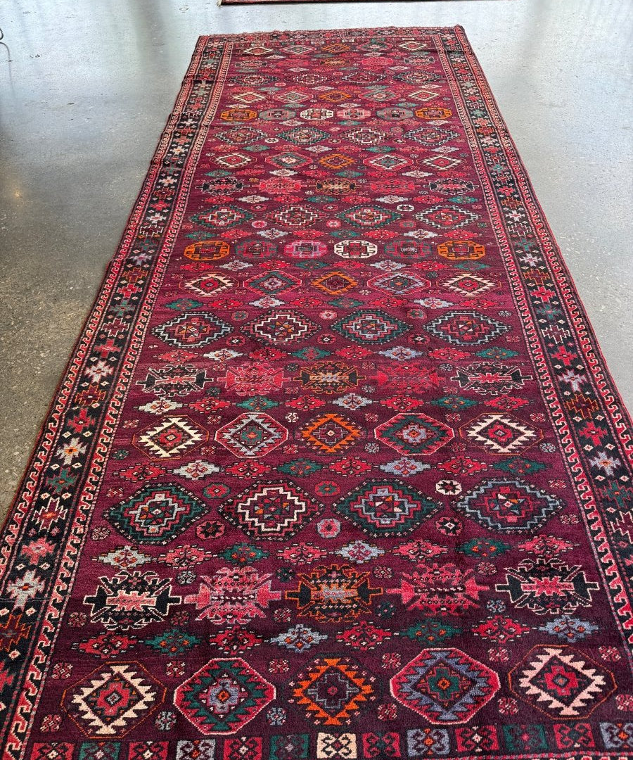 Persian Quchan rug runner with dark red center pattern and multicolor diamond border trim