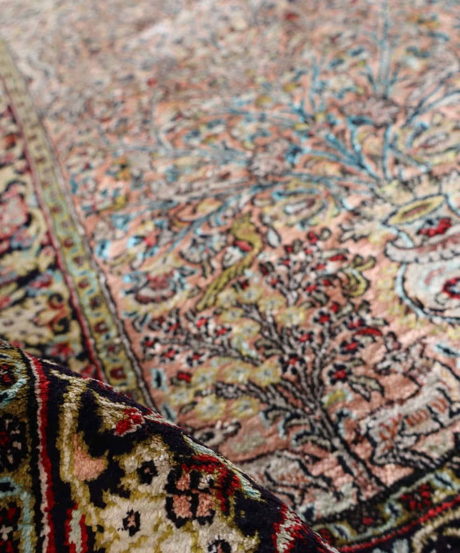 Persian Qum silk rug close-up of ornate corner pattern with blue and red accents